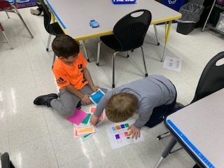 Students figuring out how to code an Indi robot in Mrs. Parker and Mrs. Wyman's after school class.   They determined which color would make the Indi stop, go, turn, spin, and more.  They then programmed the Indi to go around their partner!